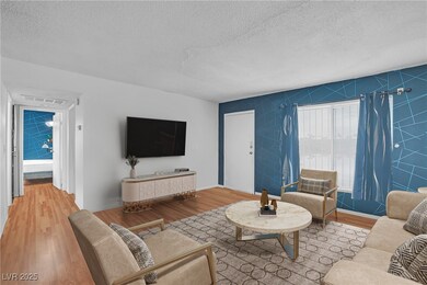 Living room featuring a textured ceiling, light wo