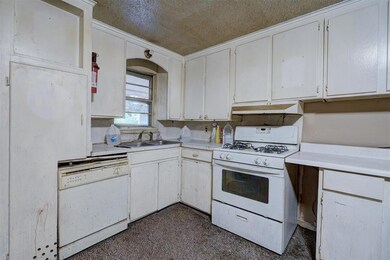 Kitchen with dark carpet, white appliances, white 
