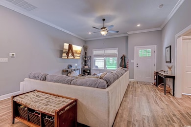 Living area featuring visible vents, crown molding