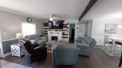 Living room featuring a ceiling fan, a fireplace, 