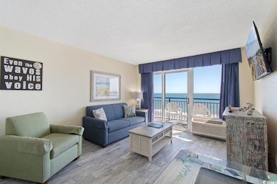 Living room with a textured ceiling, wood finished floors, and an AC wall unit