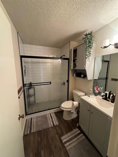Full bathroom with vanity, a stall shower, a text