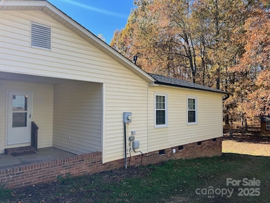Side of home showing entrance into the kitchen area and all of the utilities 