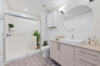 Full bathroom featuring vanity, a stall shower, l
