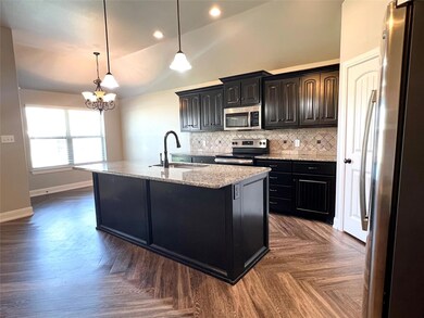 Kitchen featuring lofted ceiling, decorative light