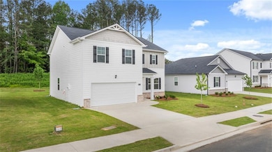 View of front facade featuring driveway, an attached garage, a front lawn, and brick siding