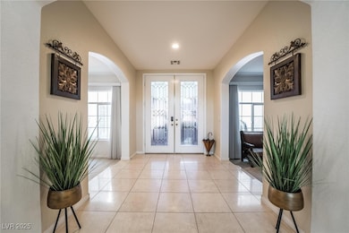 Walk in to a grand Foyer with french doors, arched