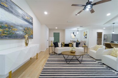 Living room with ceiling fan, vaulted ceiling, and