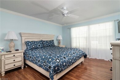 Bedroom with dark wood-style floors, crown molding