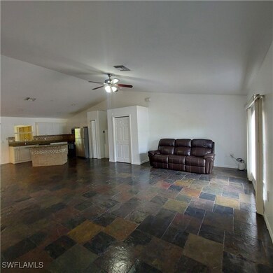 Living area with vaulted ceiling, ceiling fan, sto