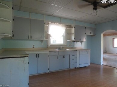 Second view of kitchen with open archway to family