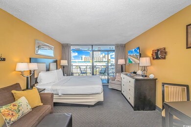 Carpeted bedroom with expansive windows, access to exterior, and a textured ceiling