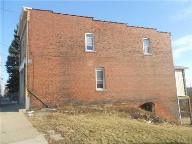 Exterior Front. Long brick building. yard in foref