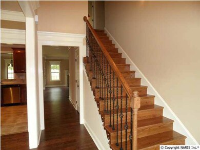 Foyer area with vaulted ceiling, hardwood floors, door with side lights on both sides, hardwood stairs on all steps.