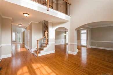 Spacious two story foyer with detailed iron stairc