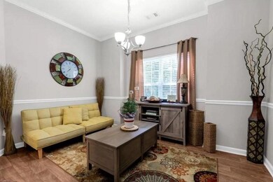 Living room featuring wood finished floors, crown 