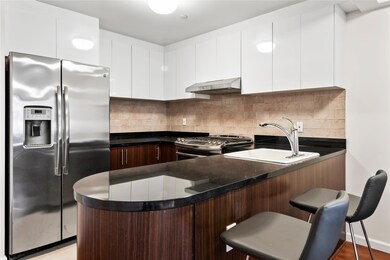 Kitchen with kitchen peninsula, stainless steel appliances, extractor fan, sink, and white cabinets