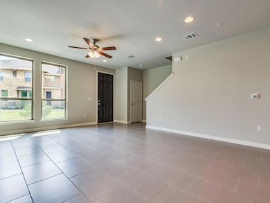Tiled spare room featuring ceiling fan and recess