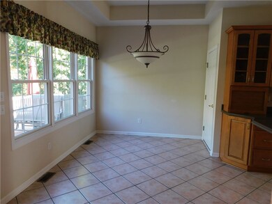 Kitchen Dinette area with a tray ceiling and hangi