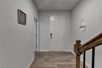 Foyer with baseboards and wood finished floors