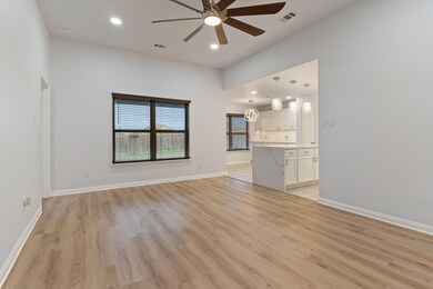 Unfurnished living room with ceiling fan and light wood-type flooring