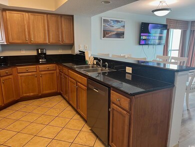 Kitchen with brown cabinets, dishwasher, a peninsu