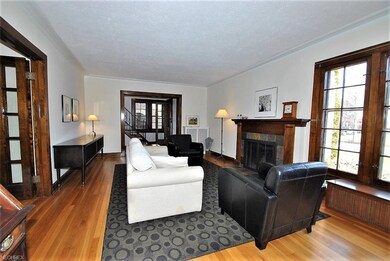 Living room has large window, hardwood, leads to d