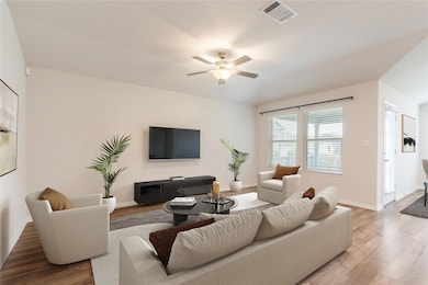 Living room with a ceiling fan, baseboards, visib