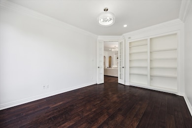 Study features a wall of built-in shelving and har