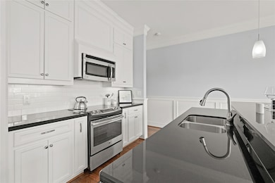 Modern kitchen with white cabinetry, stainless ste