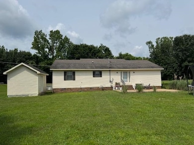 Rear view of house with a yard and crawl space