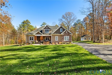 Craftsman-style house with covered porch, board and batten siding, a front lawn, and stone siding