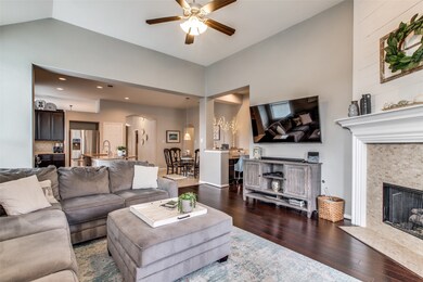 This home features high ceilings, gas log fireplace with tile surround, shiplap above mantel, and recessed lighting.