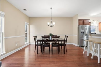 Dining space featuring dark wood-type flooring and a chandelier