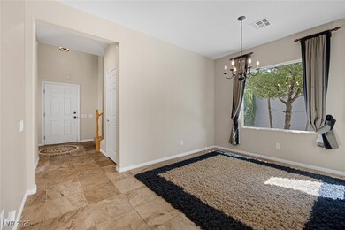 Empty room featuring a chandelier and light stone finish flooring