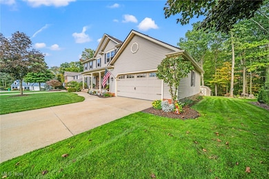 Traditional home featuring concrete driveway, covered porch, and a front lawn