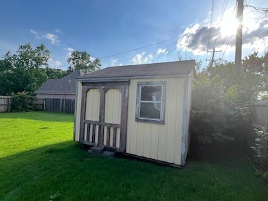 View of outdoor structure featuring a yard