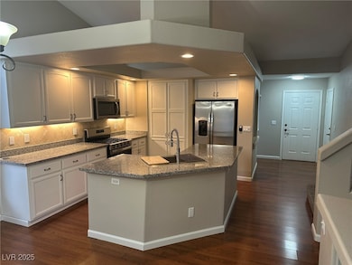 Kitchen with dark stone counters, recessed lighting, stainless steel appliances, dark wood-style flooring, and decorative backsplash