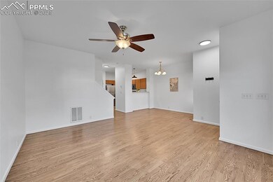 Unfurnished living room featuring light wood-style flooring, a chandelier, and a ceiling fan