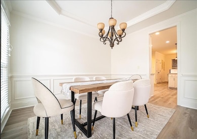 Dining room with light wood-type flooring, a chand