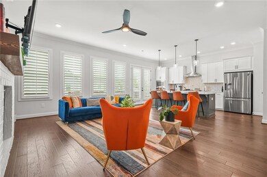 Living room with ceiling fan, baseboards, ornamental molding, recessed lighting, and dark wood-type flooring