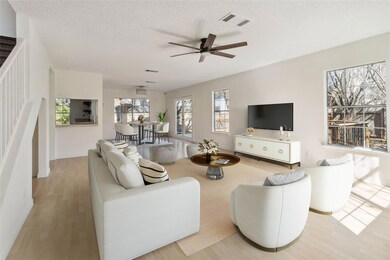Living area with a ceiling fan, a textured ceilin