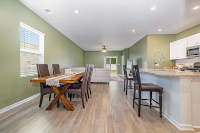 Dining room featuring a ceiling fan, light wood-st