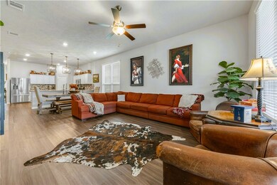 Living area with visible vents, a ceiling fan, and
