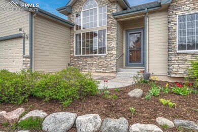 Property entrance with stone siding and an attached garage