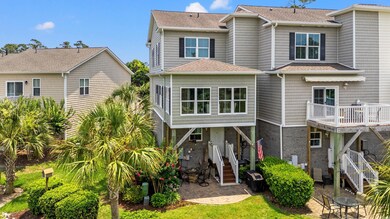 Rear view of house featuring a shingled roof and a patio