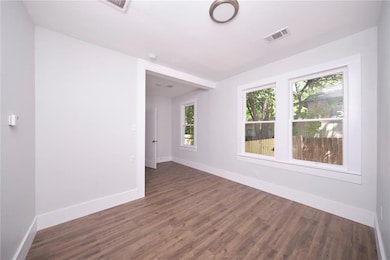 Empty room featuring wood finished floors and bas