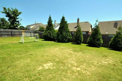 The backyard is surrounded by a wood fence for ple