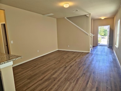 Unfurnished living room with dark wood-type flooring