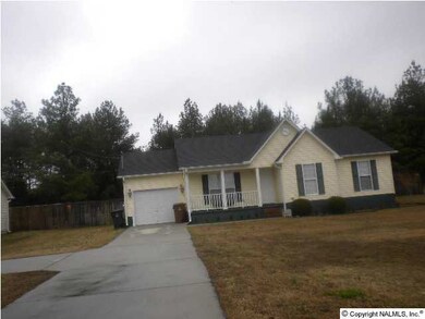 Front of home showing extra concrete parking pad and large very large yard.